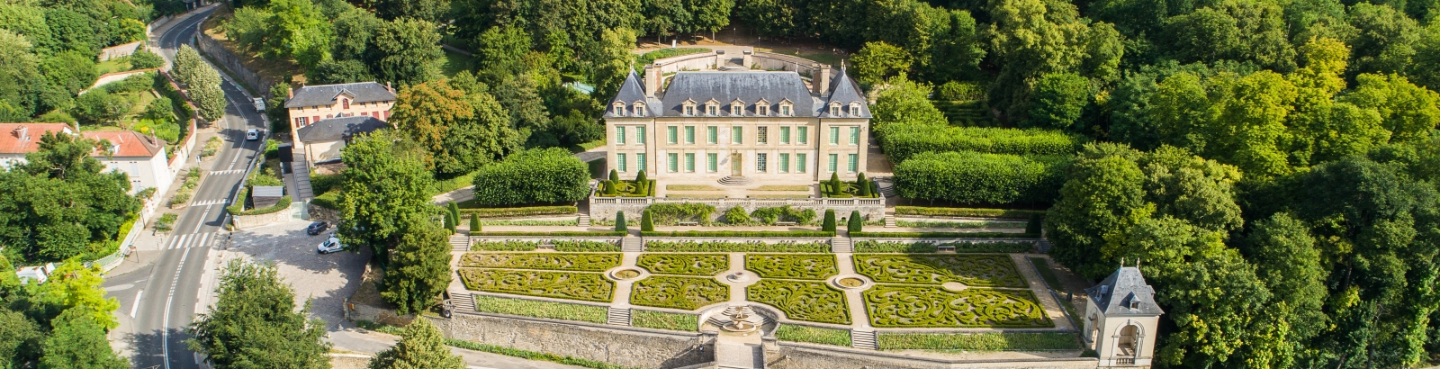 Photo du Château d'Auvers son jardin à la française et ses alentours prise en drône depuis le ciel