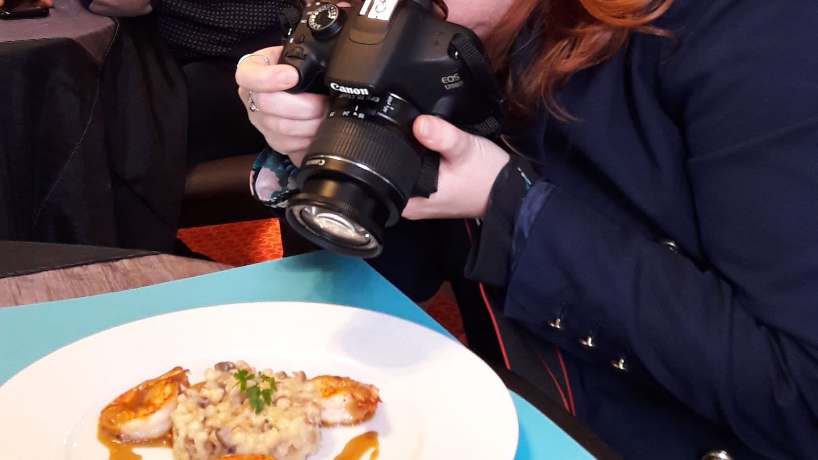 Photo d'une membre de VOT qui prend son assiette en photo au restaurant La Ferme d'Argenteuil