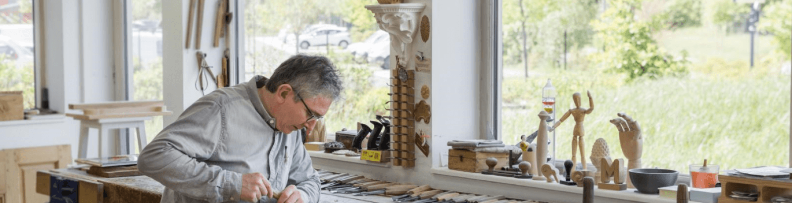 Photo de Pascal Arlot artisan d'art dans atelier, faisant de la sculpture sur bois